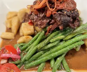 Braised beef on a bed of green beans and polenta gnocchi