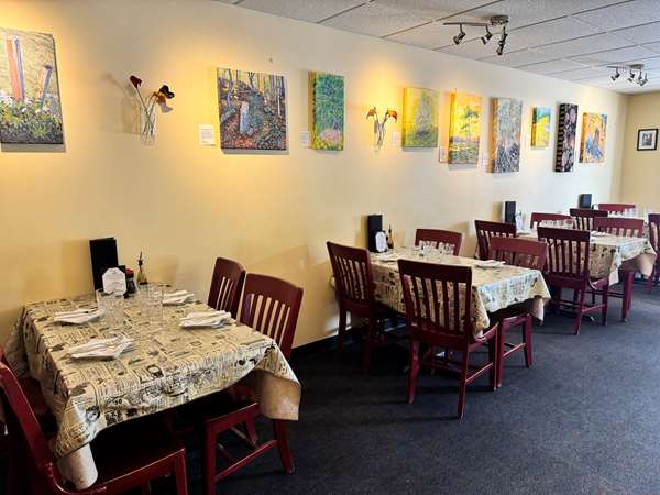 Cozy tables with a view of nature paintings by Chef Mat