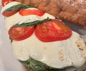 Caprese sandwich with pesto, tomato, fresh mozzarella, basil and balsamic drizzle. 